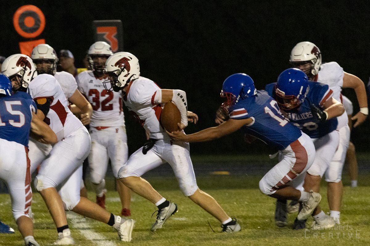 A group of football players are playing a game on a field.