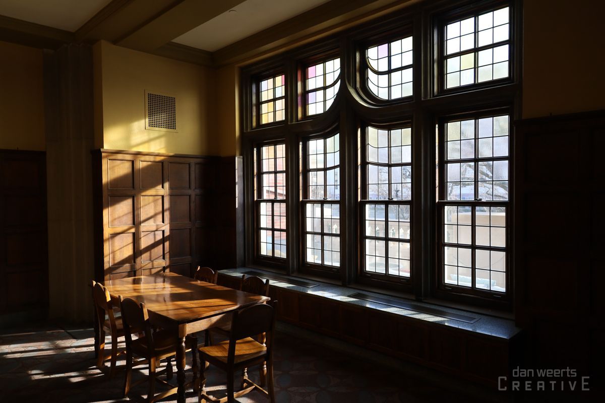 A room with a table and chairs and lots of windows