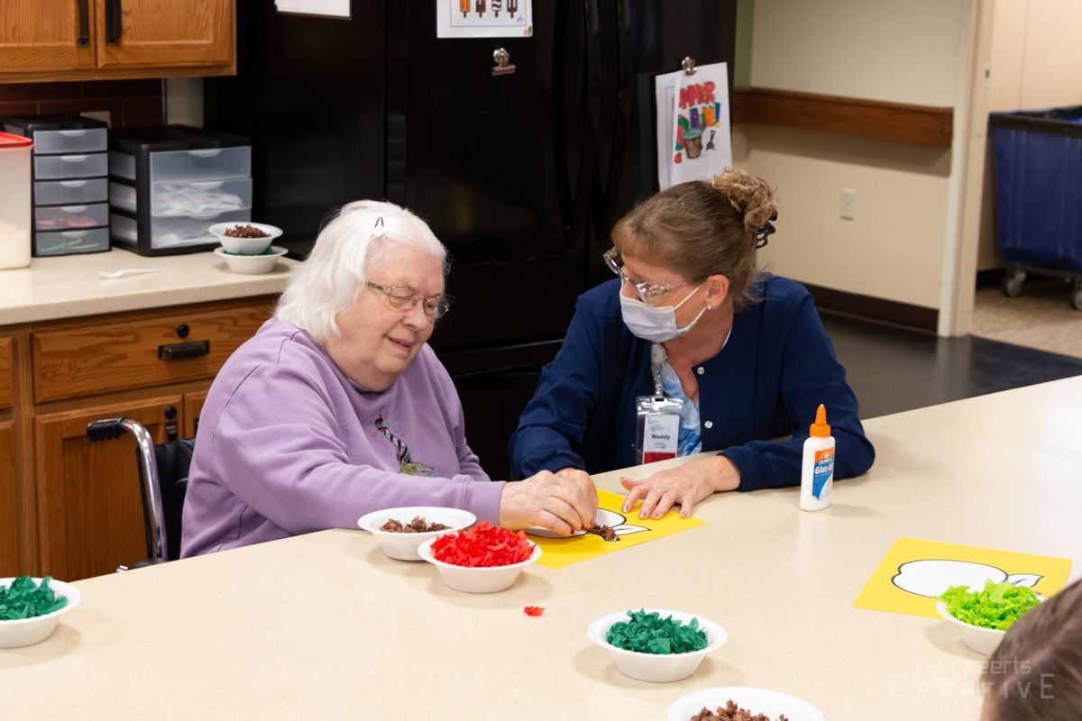 Two women are sitting at a table talking to each other.