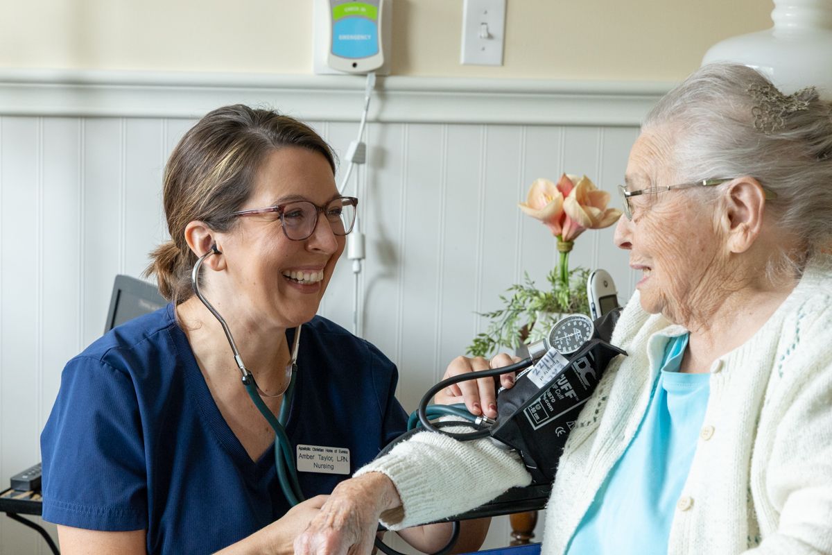 nurse checking blood pressure on nursing home resident