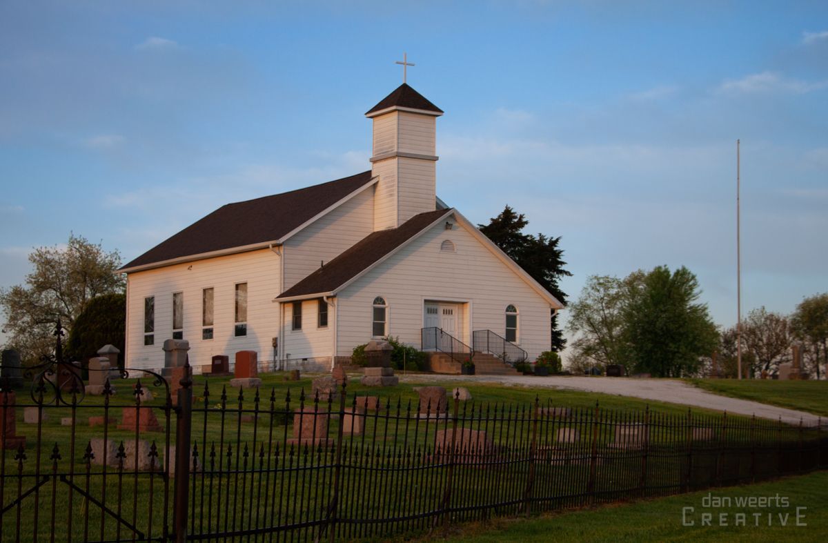 A white church with a cross on top of it