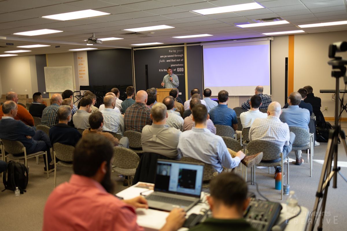 A group of people are sitting in a room watching a presentation.