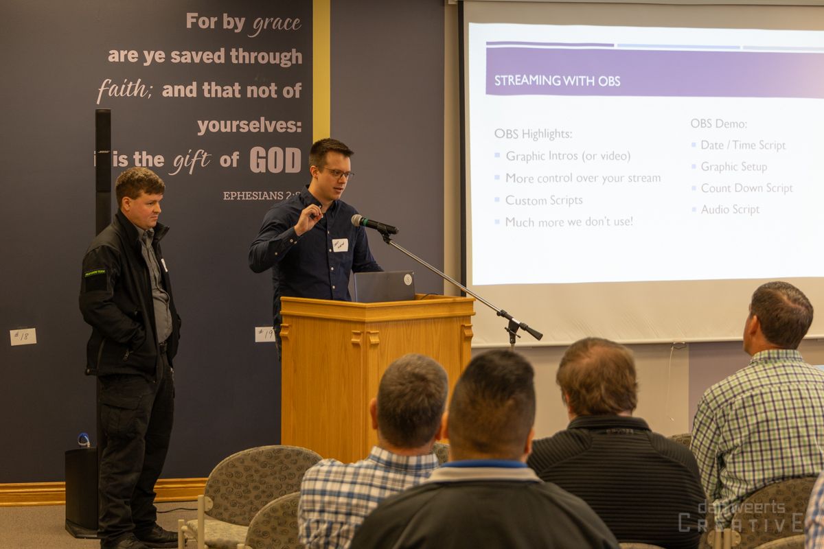 A man is standing at a podium giving a presentation to a group of people.