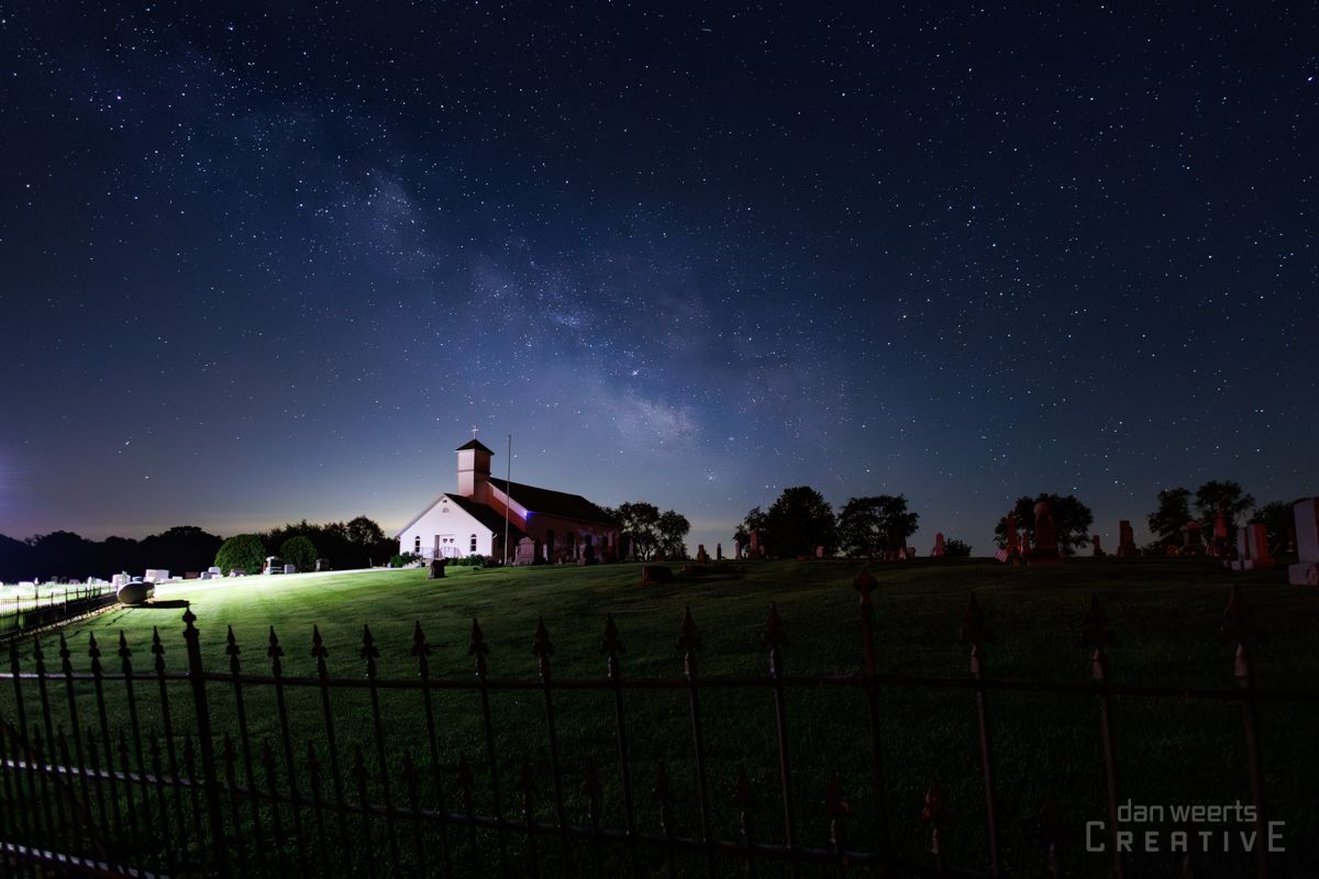 A picture of a church under a starry night sky taken by creative