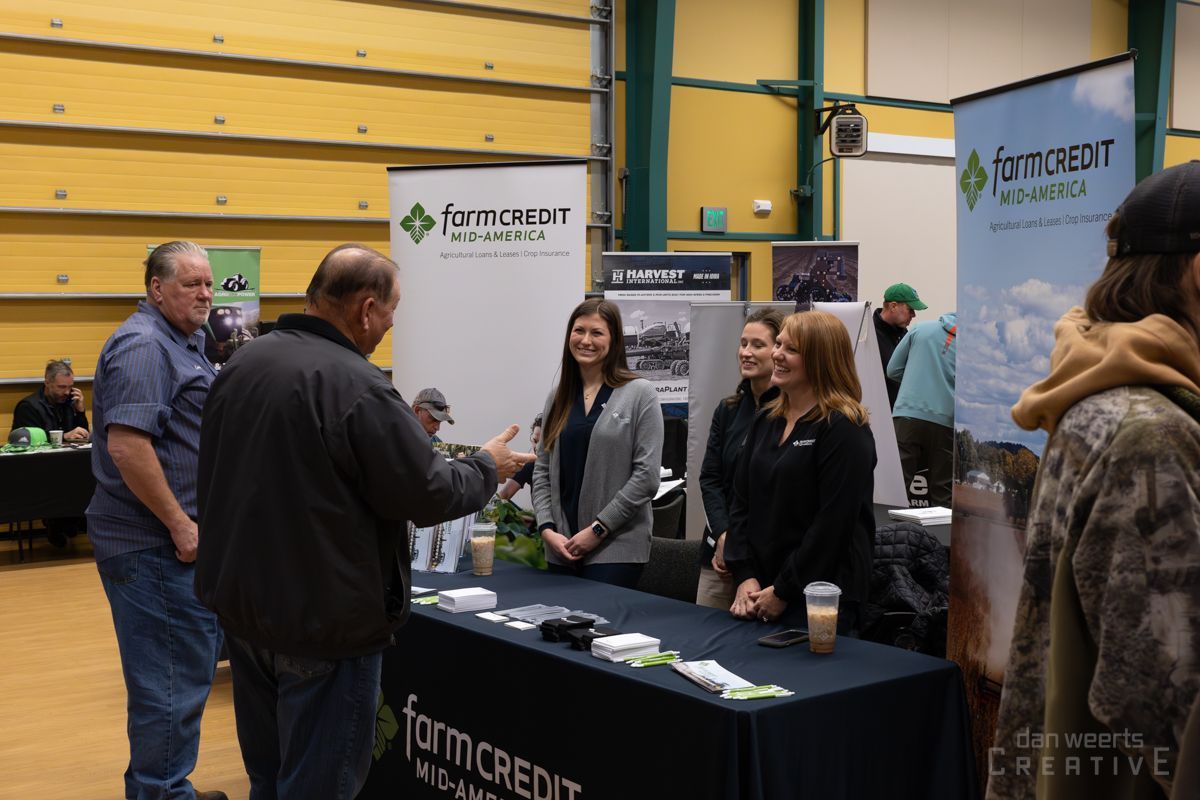 A group of people are standing around a table at a trade show