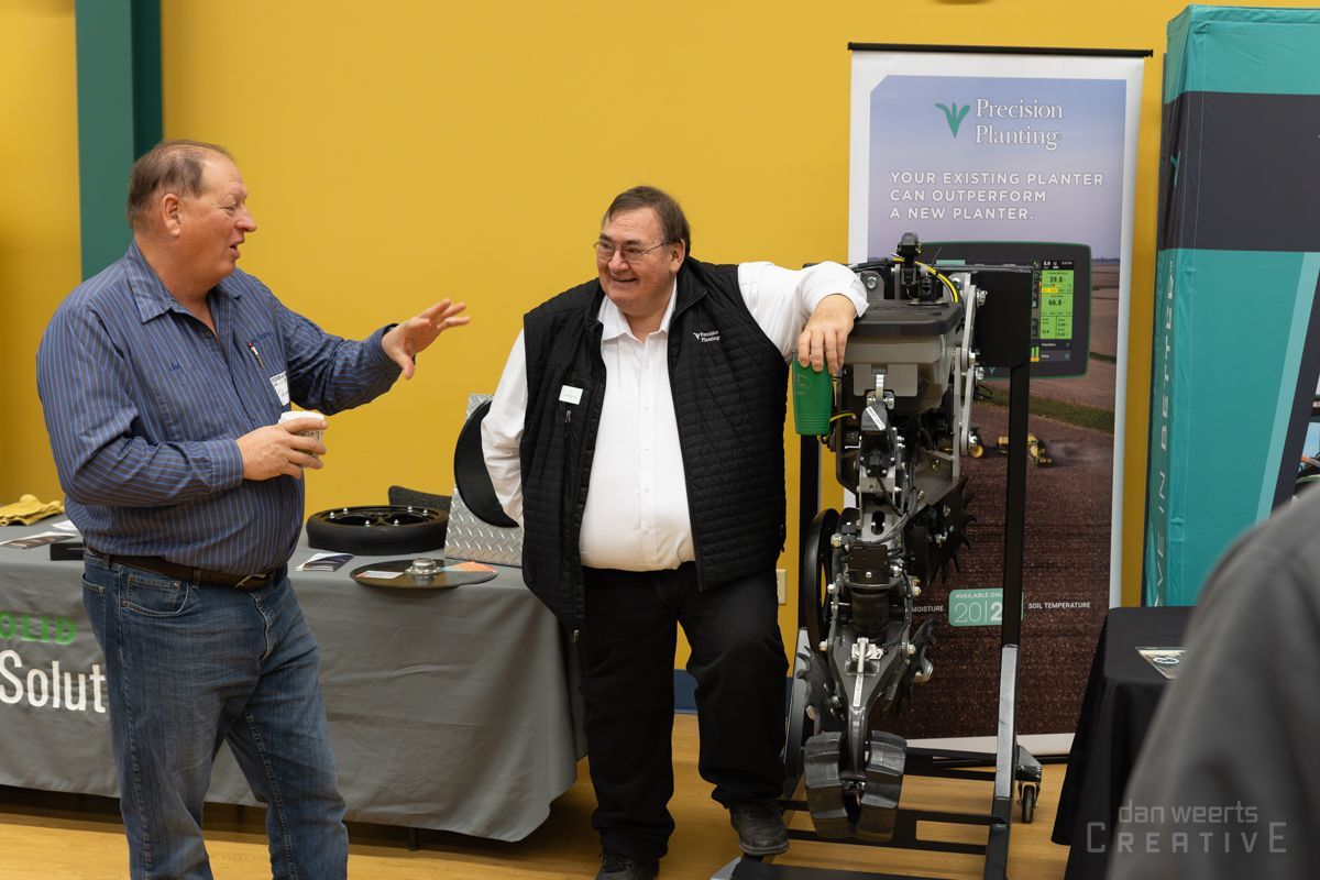 Two men are standing in front of a machine and talking