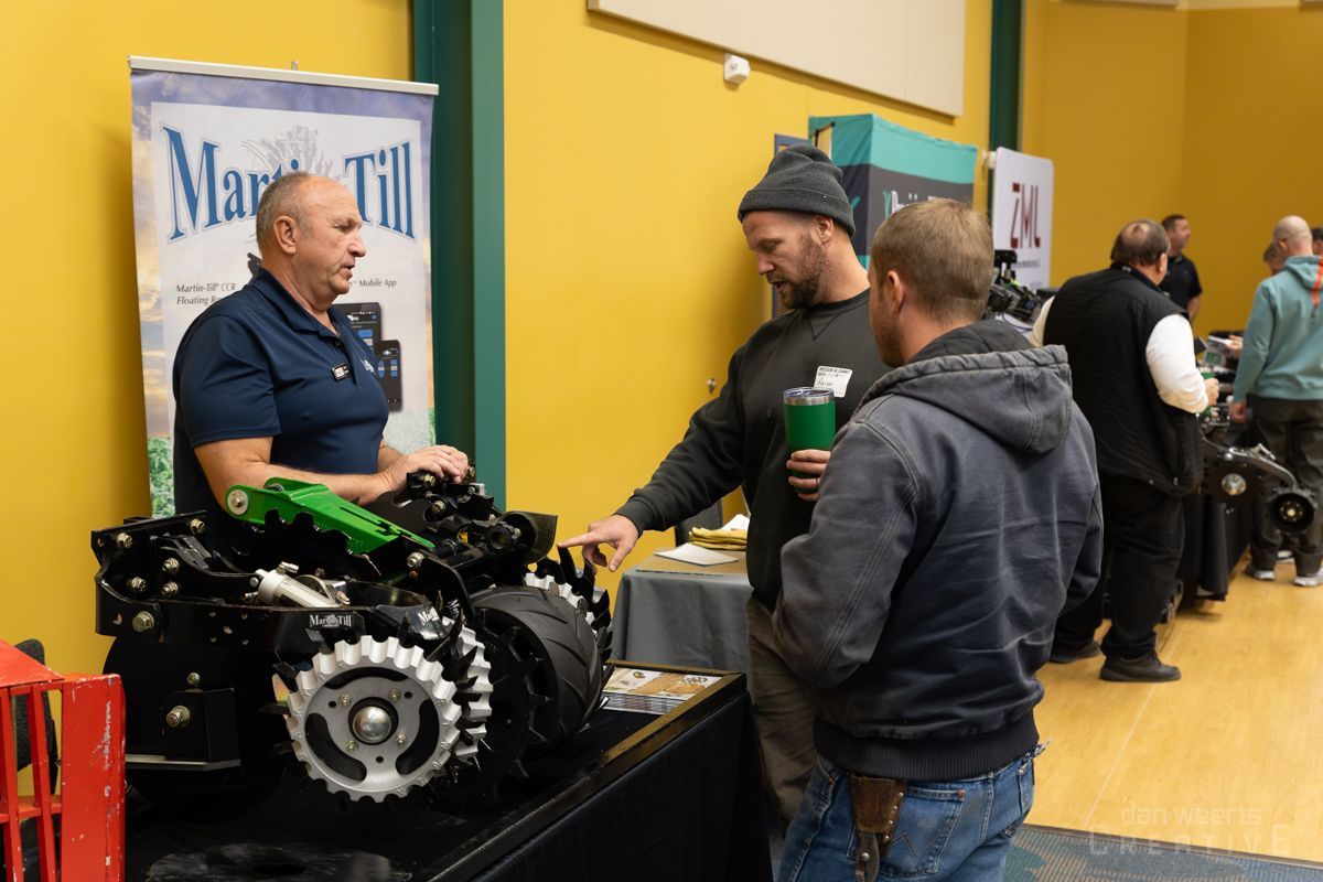 A group of men are standing around a table looking at a machine.
