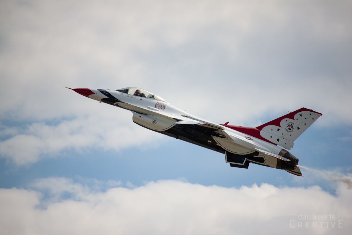 A fighter jet is flying through a cloudy sky.