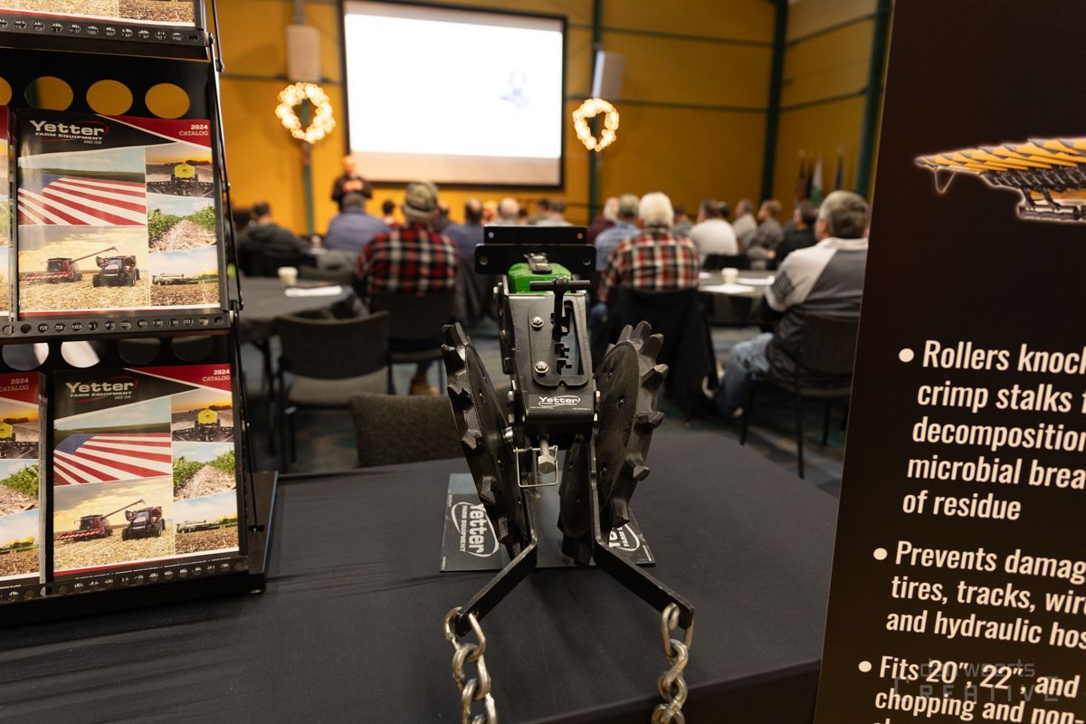 A group of people are sitting at tables in front of a projector screen
