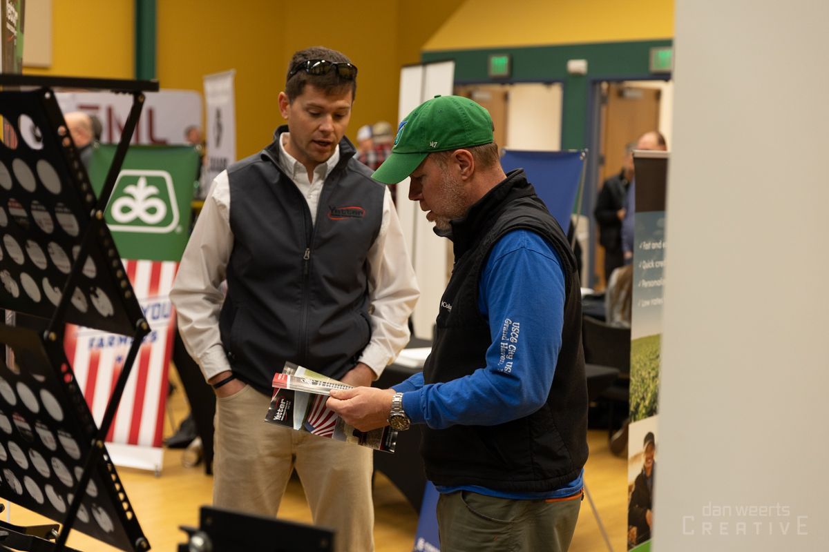 Two men are standing next to each other in a room looking at something.