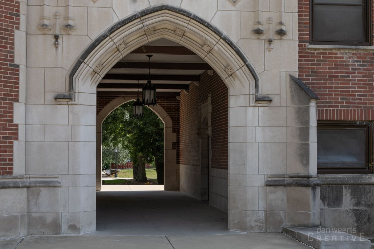 A stone archway leading to a brick building