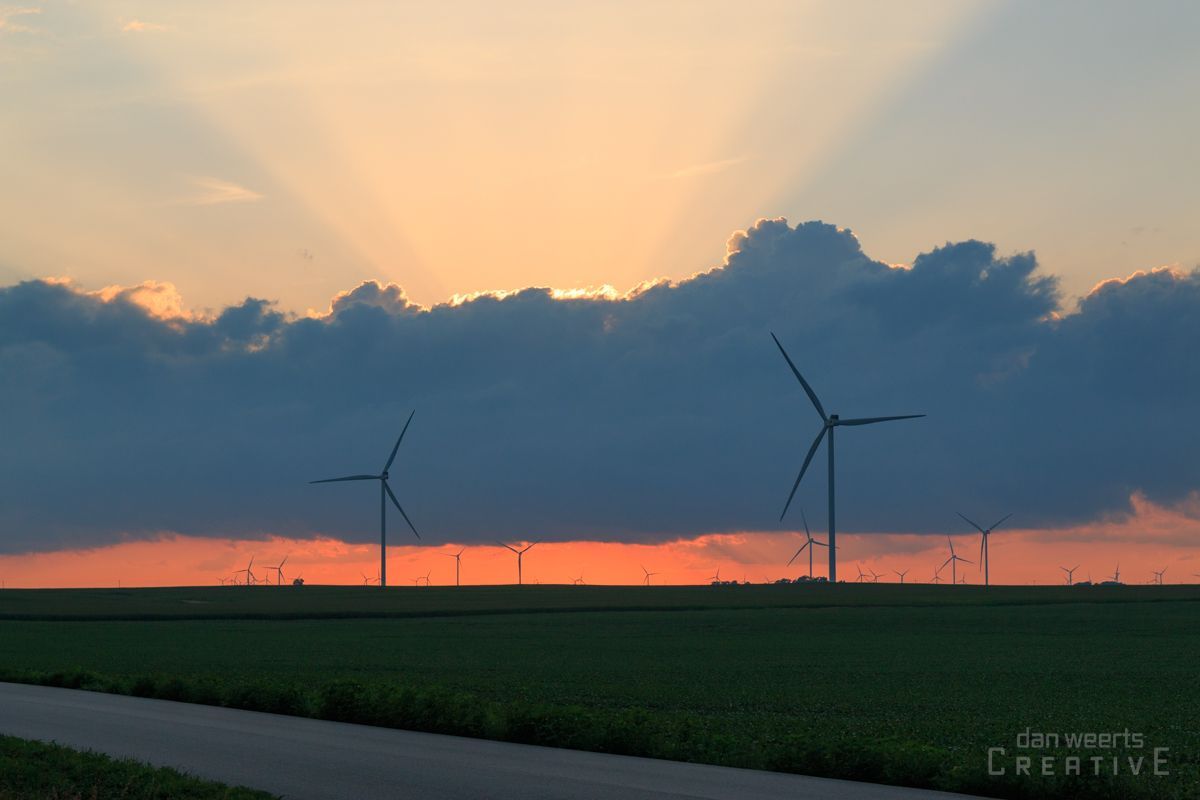 A sunset with wind turbines in the foreground