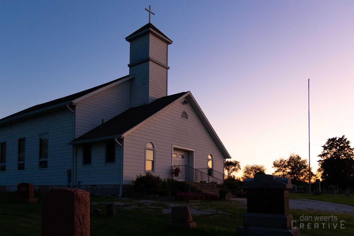 A white church with a cross on top of it