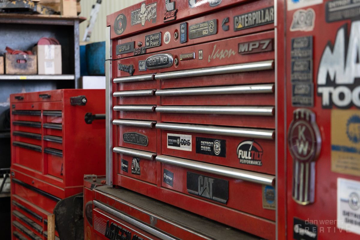 A red toolbox with a lot of stickers on it