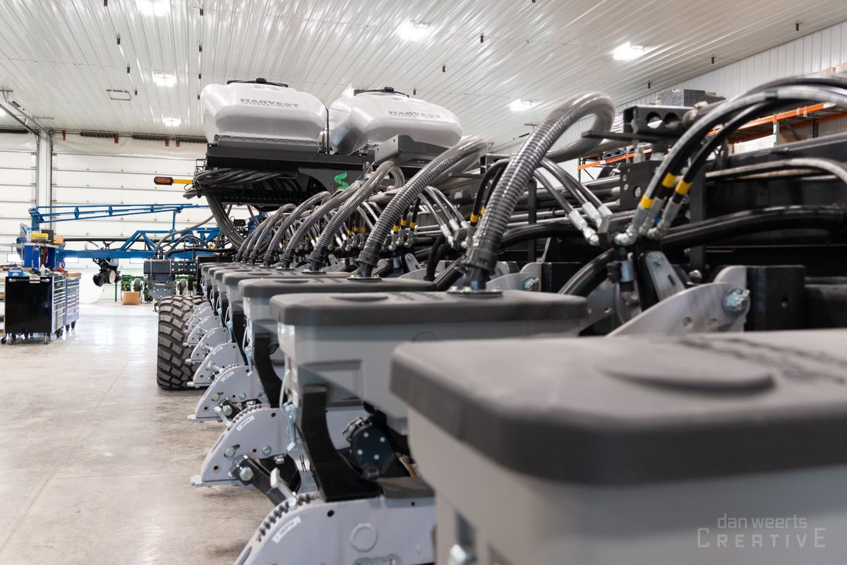 A row of planters are lined up in a warehouse.