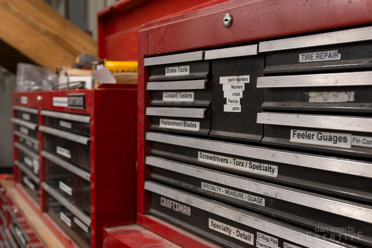 A row of red tool boxes are lined up in a warehouse.