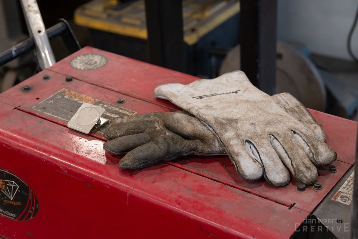 A pair of welding gloves are sitting on top of a red box.
