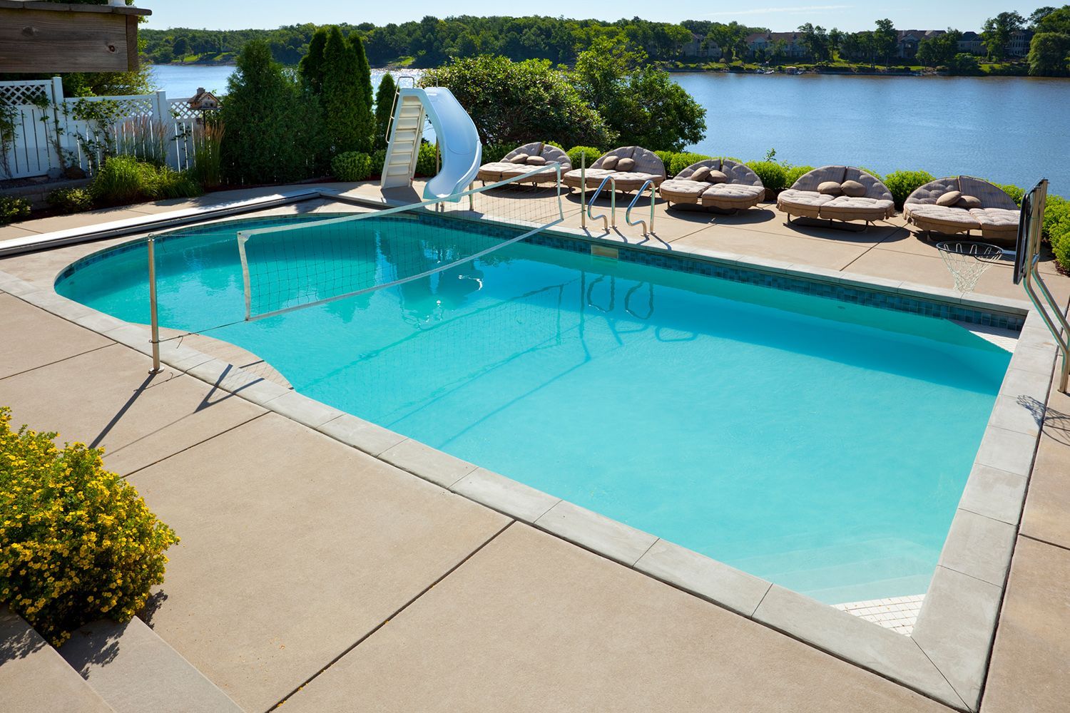 A large swimming pool with a water slide in the background