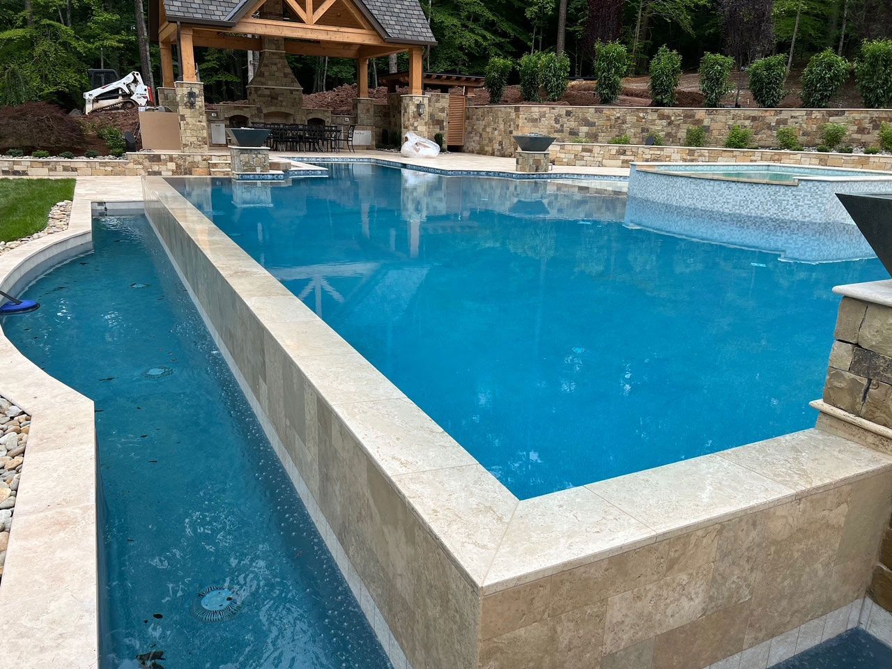 A large swimming pool with a gazebo in the background