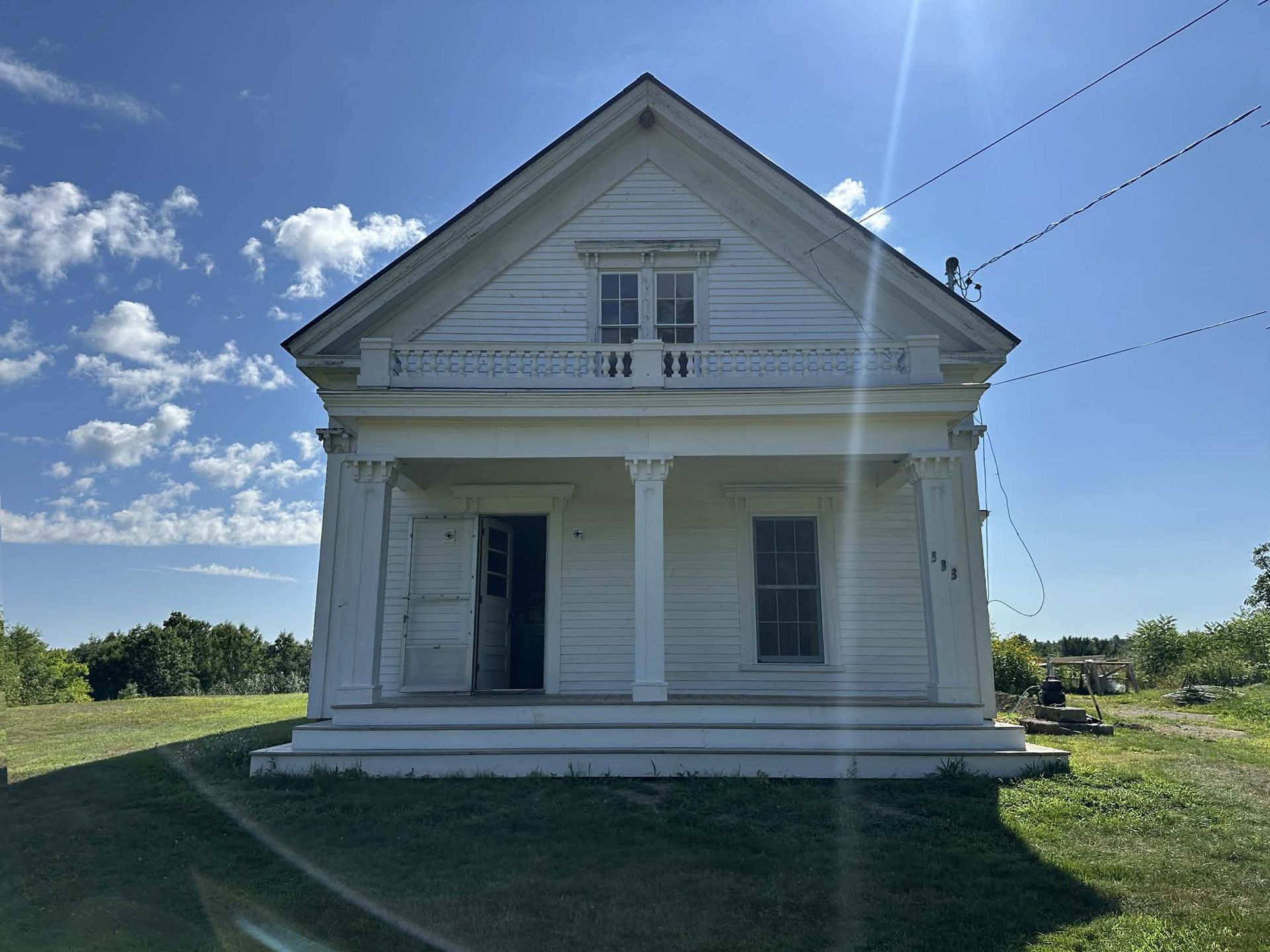 A large house with a porch and columns is being remodeled.