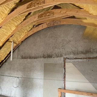 A room with a wooden ceiling and a concrete wall.