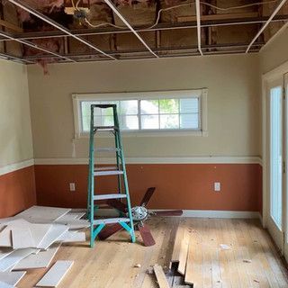 A room with a ladder and a ceiling fan in it.
