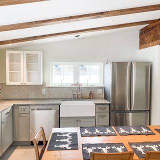 A kitchen with a table , chairs , refrigerator , sink and dishwasher.