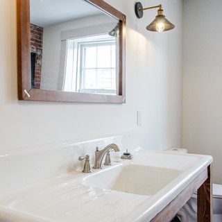 A bathroom with a sink , mirror and toilet.
