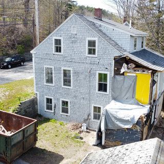 An aerial view of a house with a dumpster in front of it.