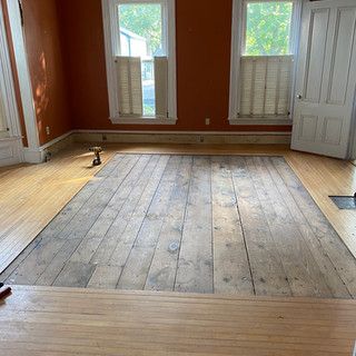 A room with a wooden floor and a drill in it.