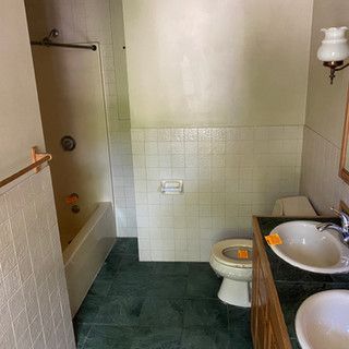 A bathroom with a toilet , sink and bathtub.