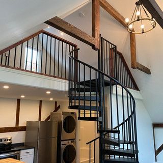 A kitchen with a spiral staircase leading to the second floor.