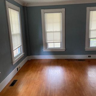 An empty living room with hardwood floors and blue walls.