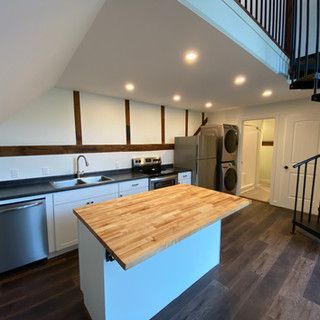 A kitchen with a large wooden island in the middle of it.
