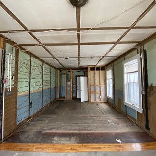 An empty room with a wooden floor and a ceiling.