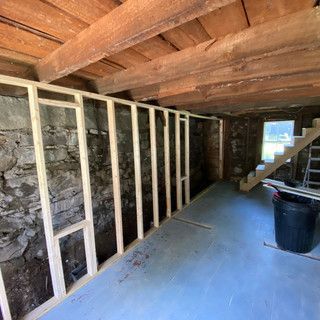 A room with a wooden wall and stairs in it.
