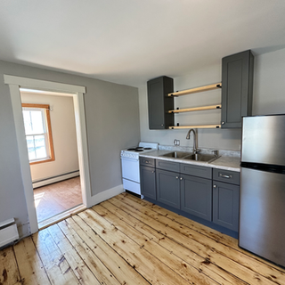 A kitchen with stainless steel appliances and wooden floors