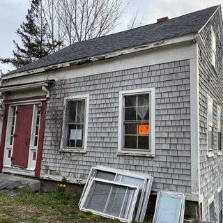 A small house with a lot of windows and a red door.