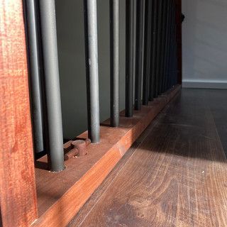 A close up of a wooden railing on a wooden floor.