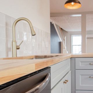 A kitchen with a sink , dishwasher , and faucet.