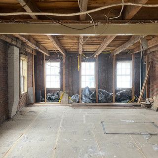 An empty room with brick walls and wooden beams.