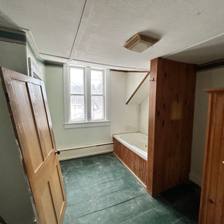 A bathroom with a bathtub and a window