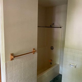 A bathroom with a bathtub and a shower stall.