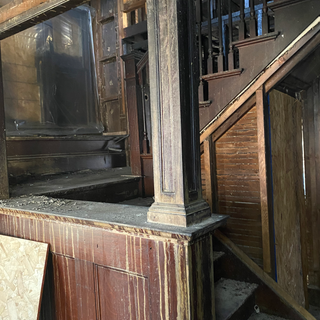 A wooden staircase with a railing in an old building.