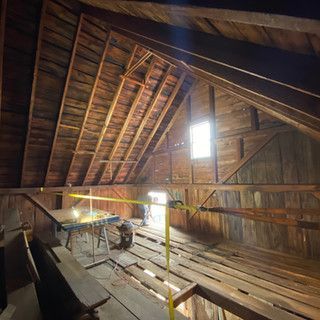 A wooden attic with a table and a window.
