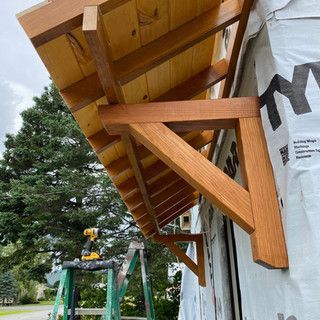 A wooden awning is being built on the side of a building.