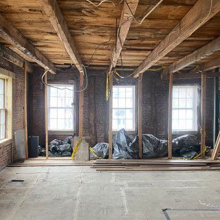 A room with a wooden ceiling and brick walls is being remodeled.
