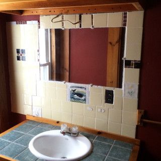 A bathroom with a sink and a mirror with a picture of a whale on it