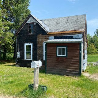 A small house with a mailbox in front of it.