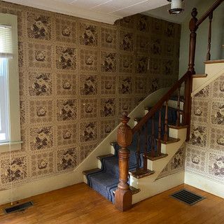 There is a staircase in the middle of a room with a wooden railing.